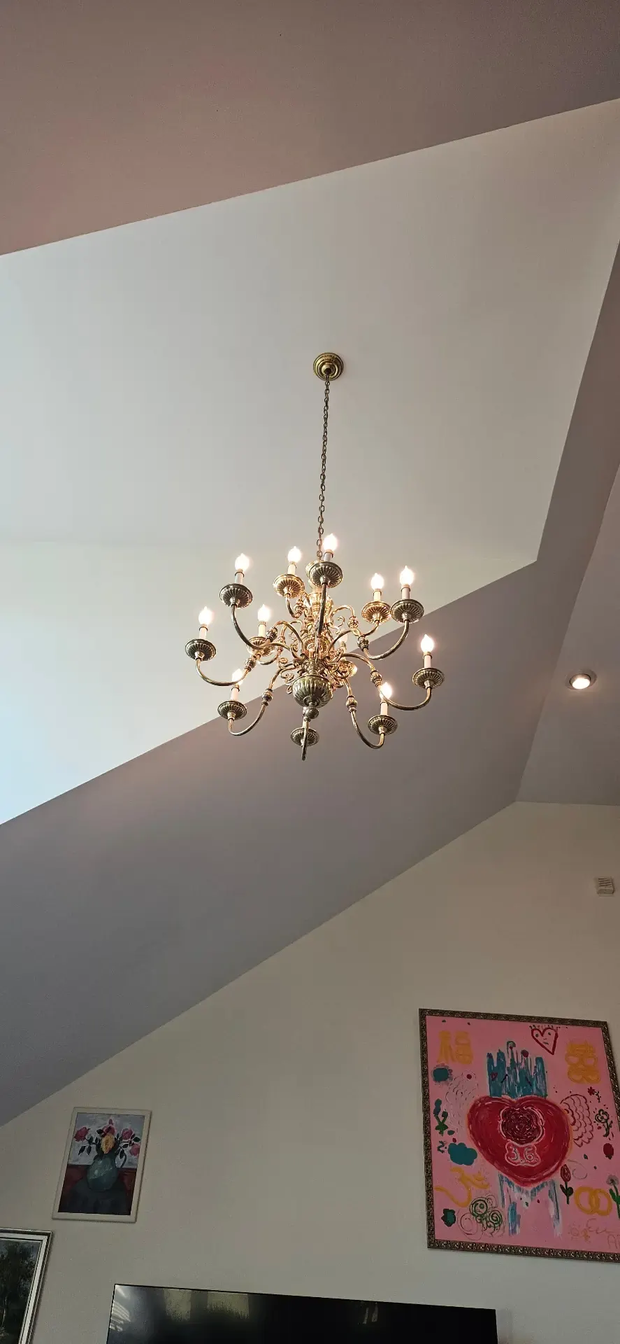 Brass chandelier hung from a tall vaulted great room ceiling