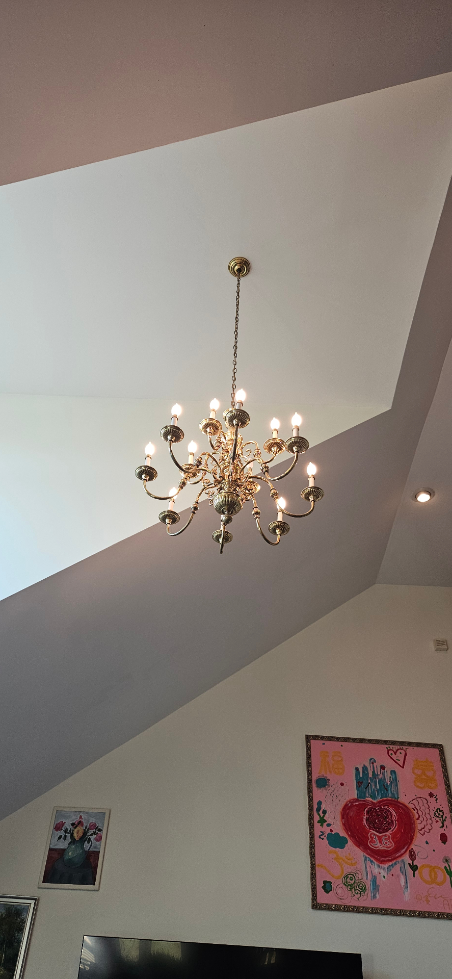 Brass chandelier hung from a tall vaulted great room ceiling