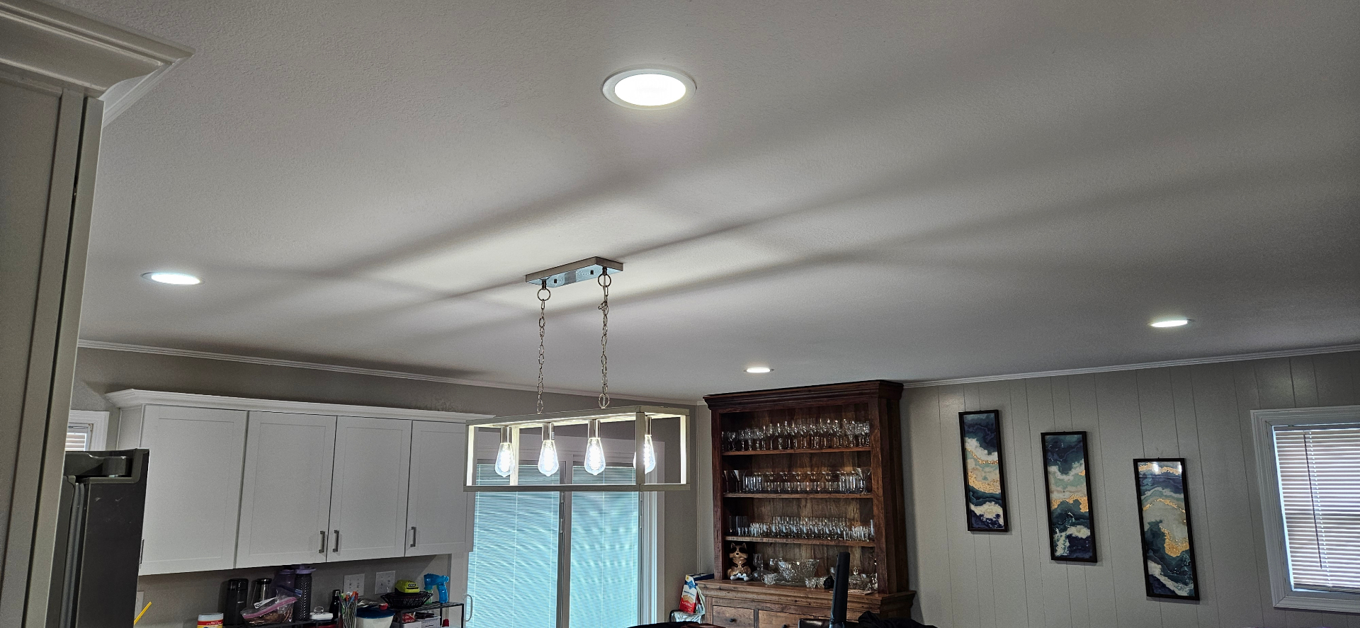 Kitchen ceiling with new recessed can lights and a modern pendant fixture